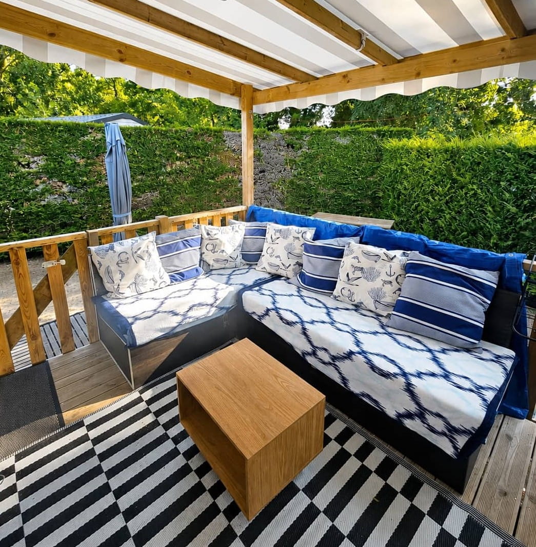 Terrasse couverte avec canapé d'angle extérieur confortable